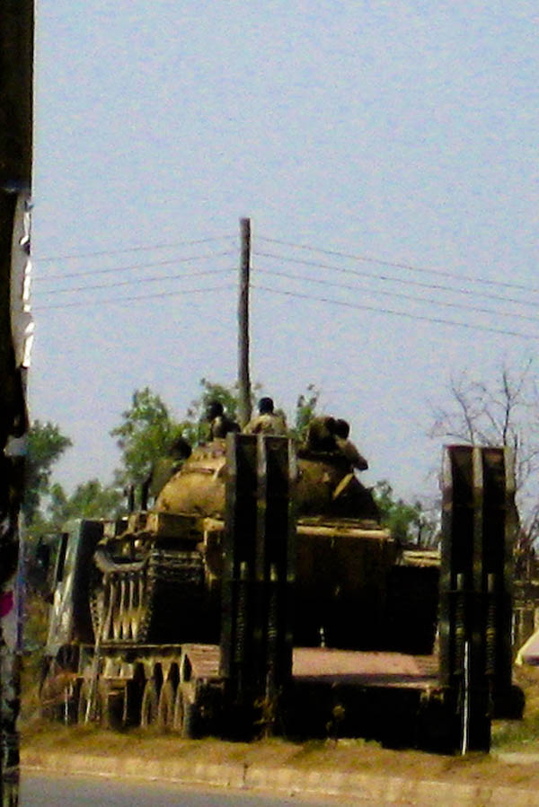 Young SPLA soldiers ride through Juba atop a tank on a flatbed truck